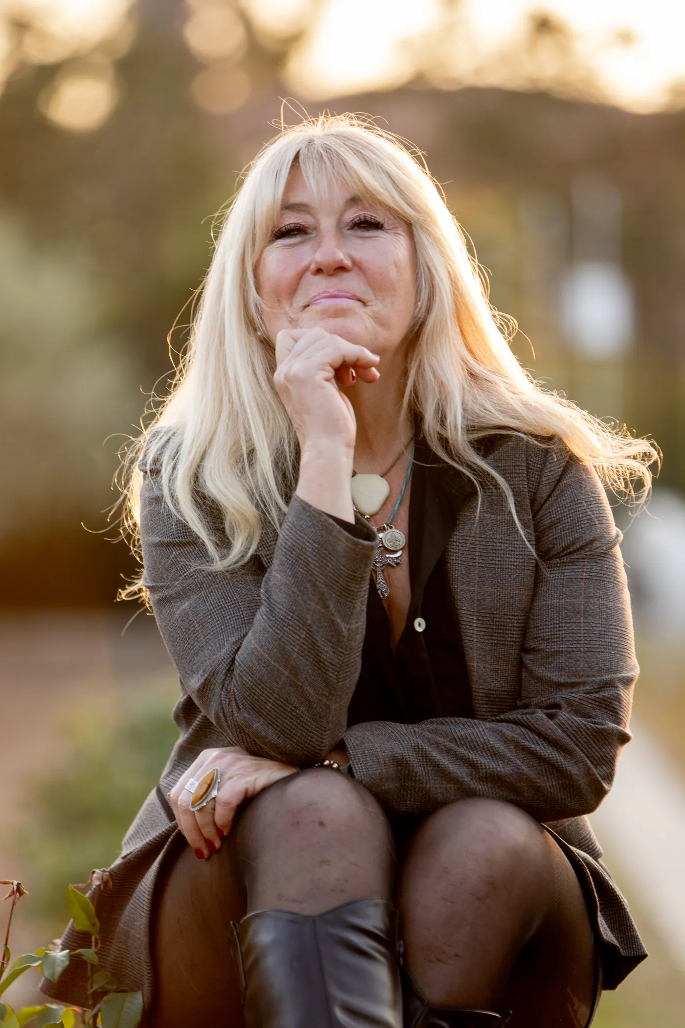 Rachel Paling seated in a sunlit garden, resting her chin on her hand