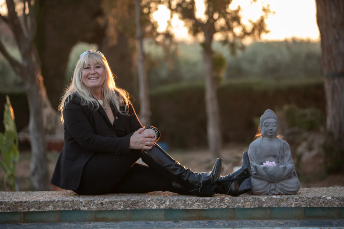 Rachel sitting in a garden beside a pool